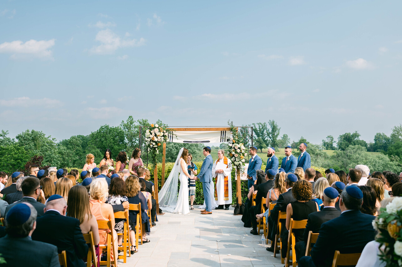 Outdoor wedding ceremony at Shadow Creek with a floral chuppa